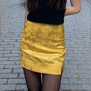 Yellow silky mini skirt with flower detail and slit
